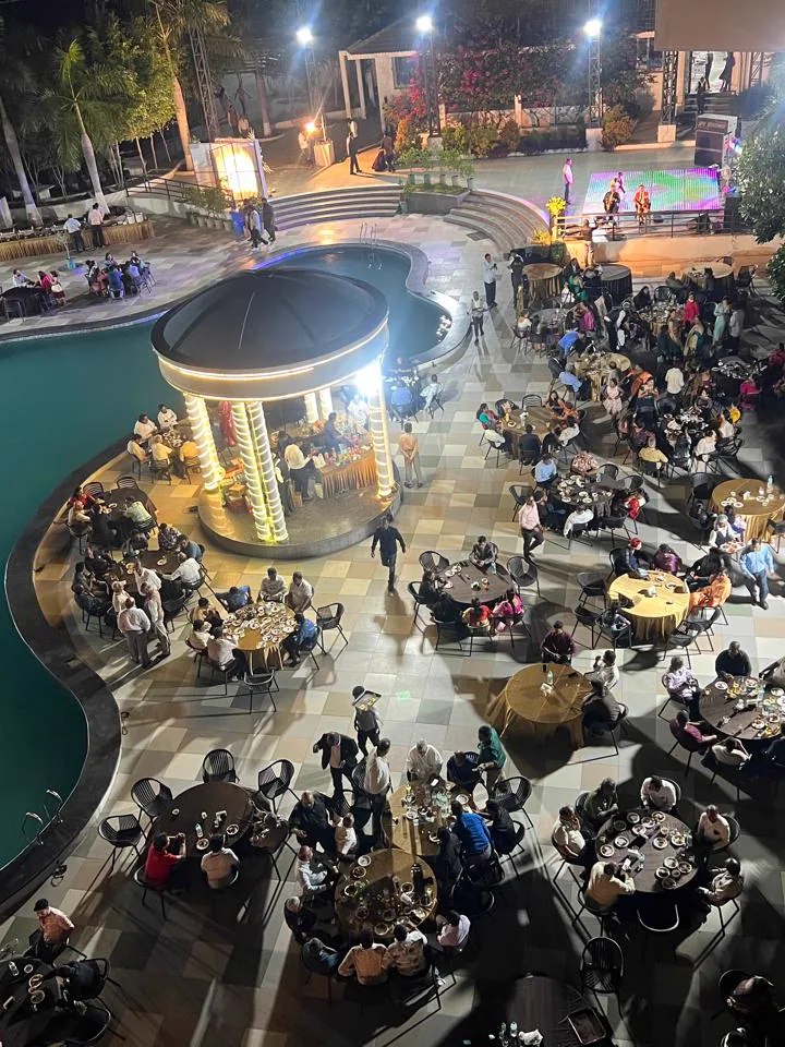 An evening dinner around the lit pool and gazebo