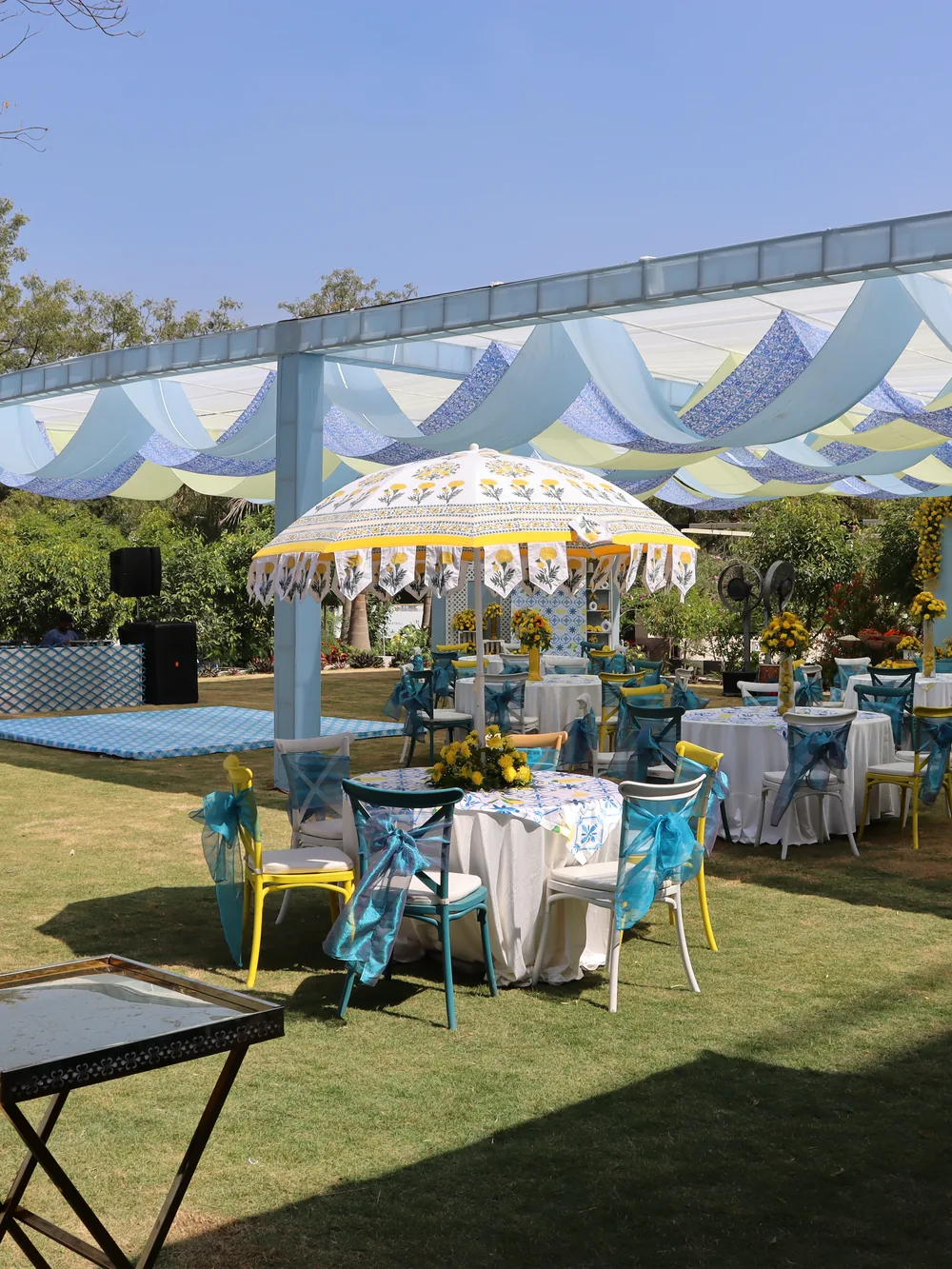 A lawn dressed with a stage, dance floor and parasols